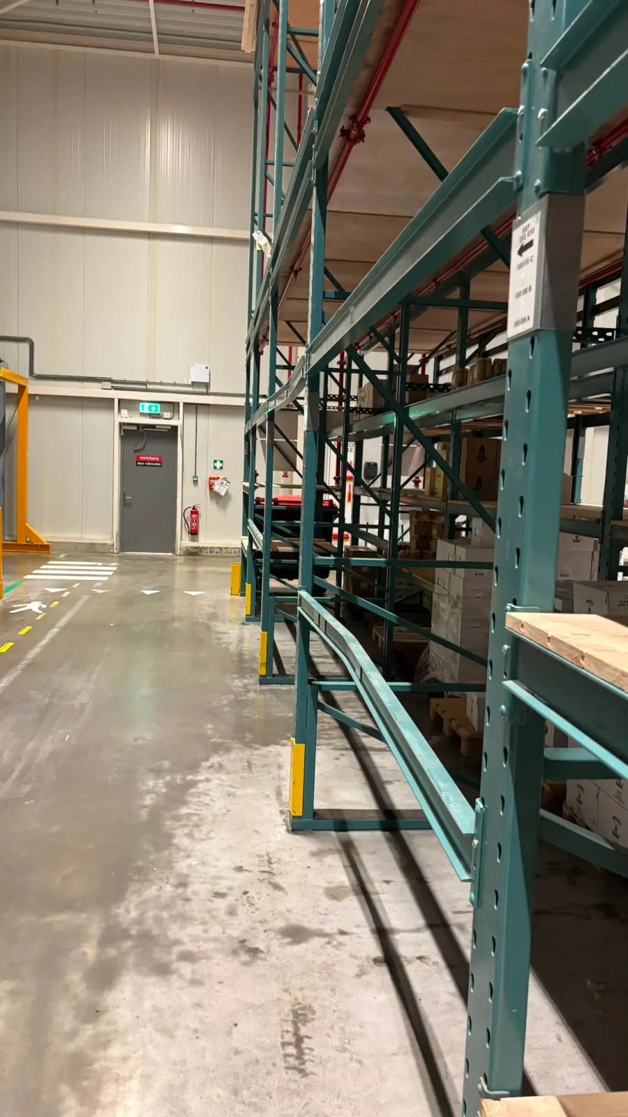 Verbogen onderligger van een palletstelling in een magazijngang